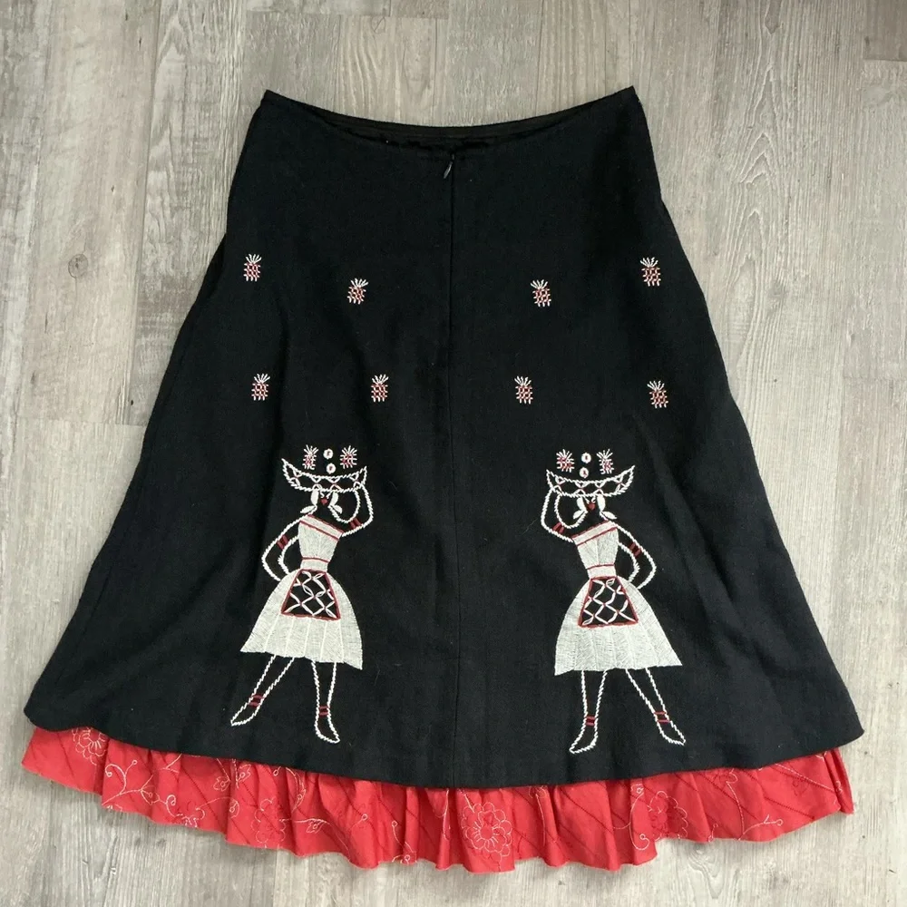A-line midi skirt with white and red embroidered figures and a ruffled red hem🌻